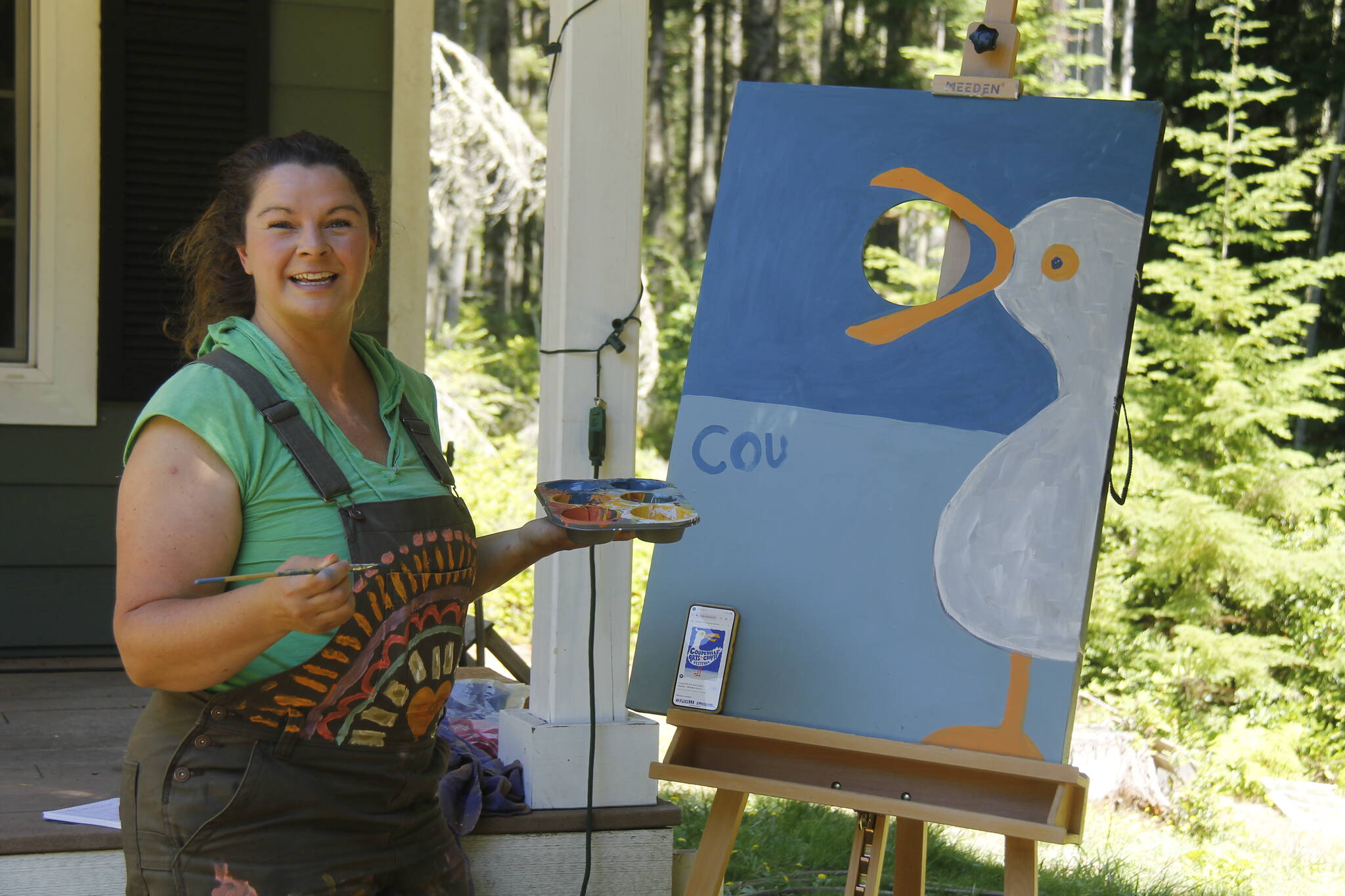 Rachel Phillips paints a cornhole board for the Coupeville Arts and Crafts Festival. (Photo by Kira Erickson/South Whidbey Record)