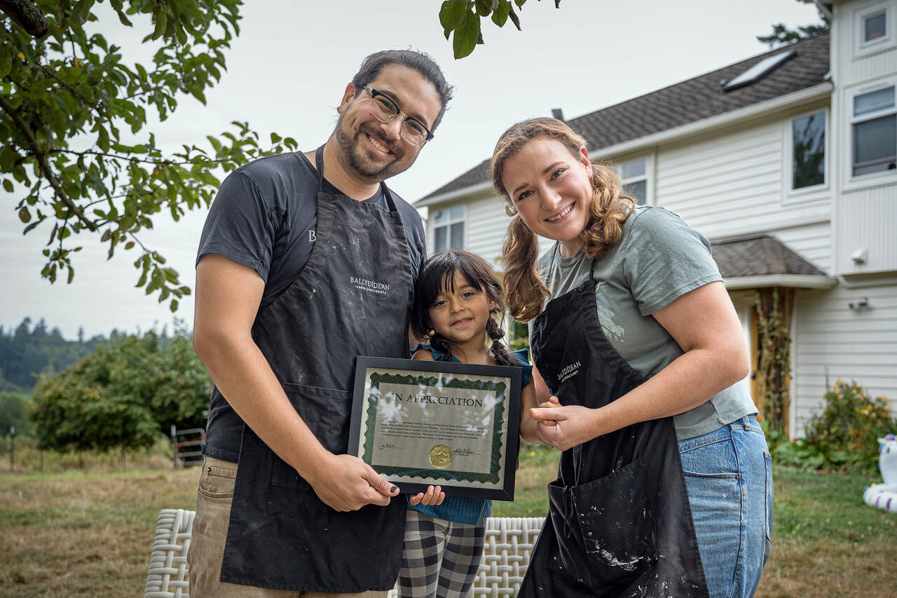 Photo by David Welton
From left, Ansel, Gwen and Sarah Santosa hold the award presented to Ballydidean Farm Sanctuary by the Island County Sheriff’s Office.