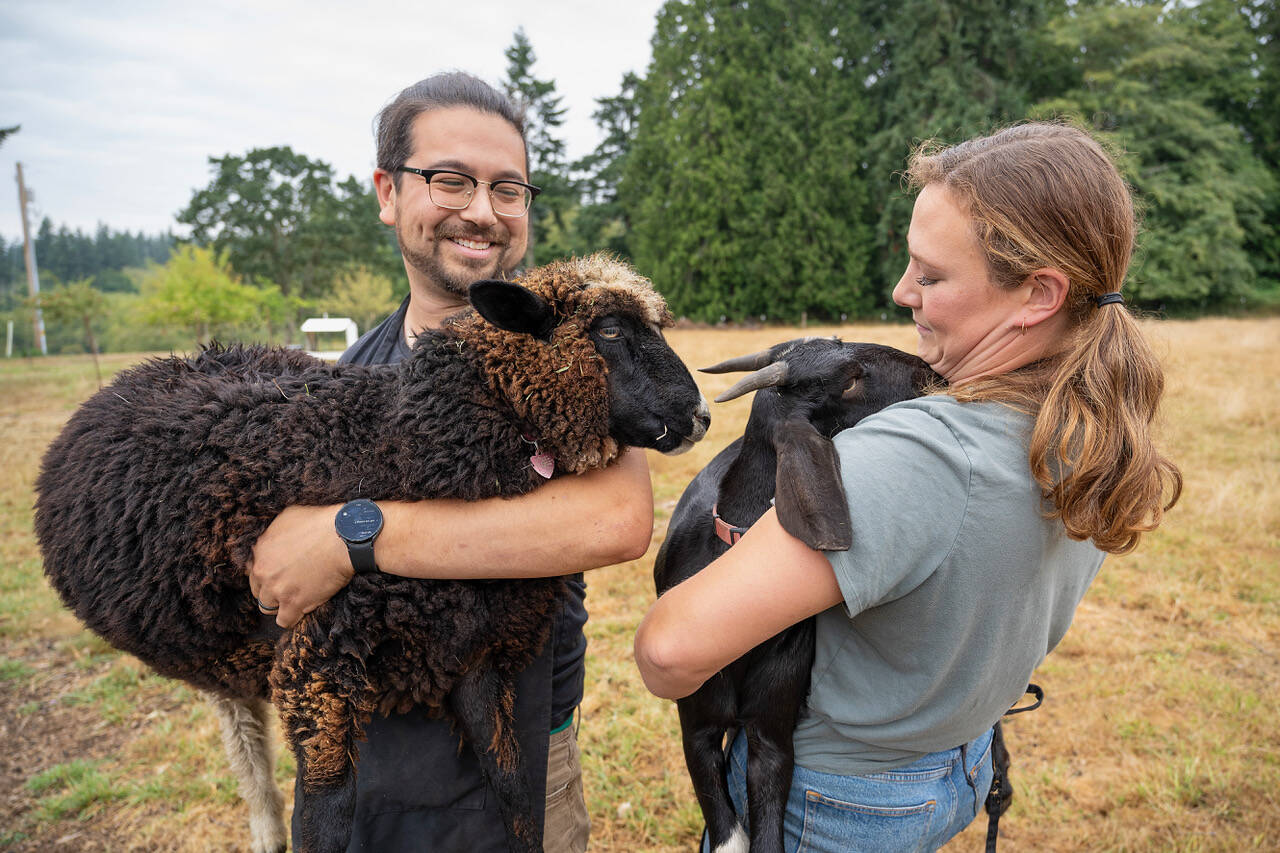 Photo by David Welton
Ansel Santosa holds Clare the sheep, while Sarah Santosa carries Lucy the goat.
