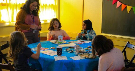 Photo by Luisa Loi/Whidbey News-Times
Claudia Kiyama watches a group of girls create art at WILASC's open house event.