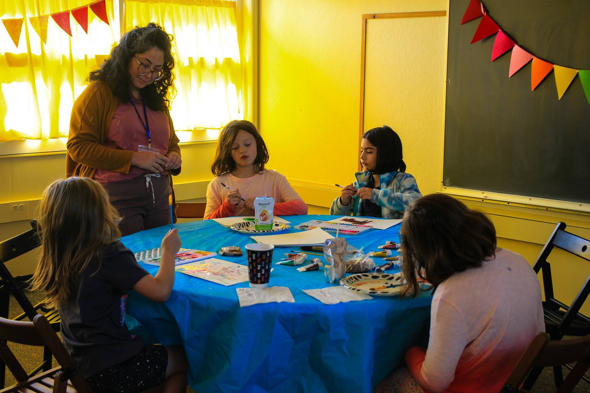 Photo by Luisa Loi/Whidbey News-Times 
Claudia Kiyama watches a group of girls create art at WILASC’s open house event.