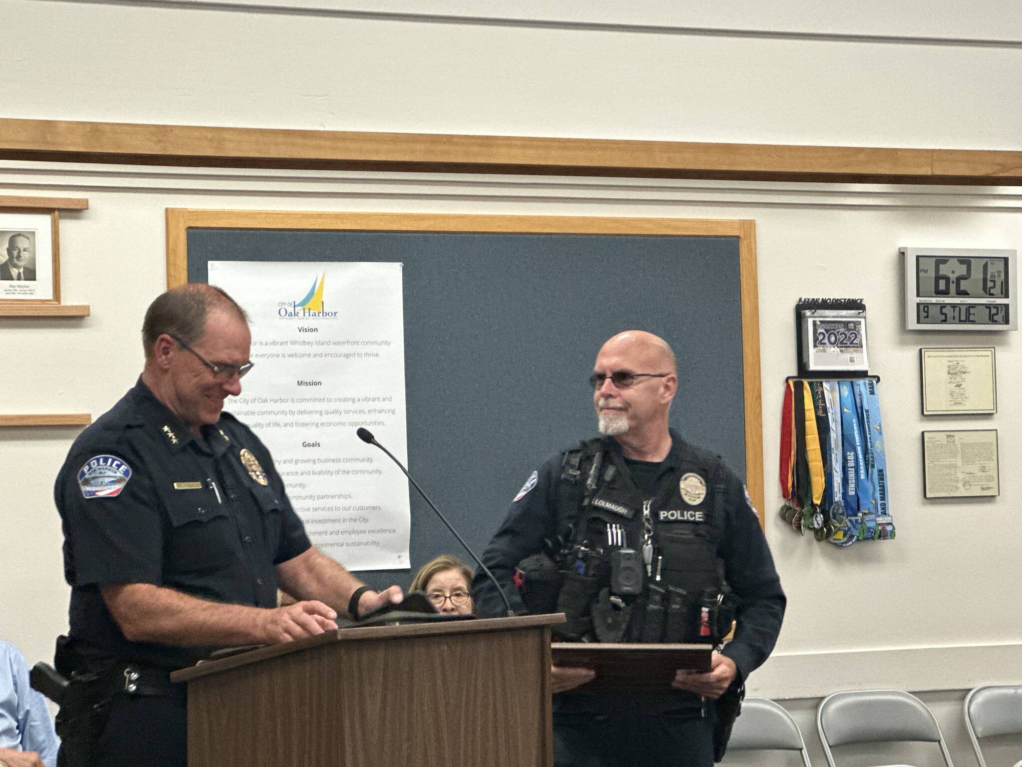 Oak Harbor Police Officer Mel Lolmaugh, right, receives the Emergency Treatment Award at a city council meeting Sept. 5. (Photo provided)