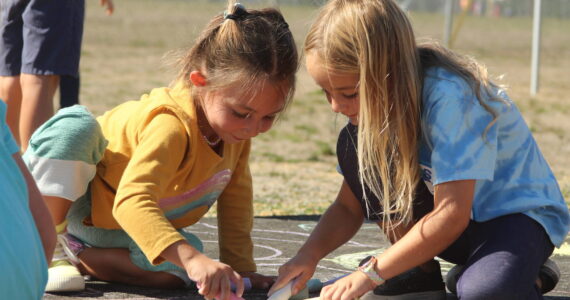 Photo by Karina Andrew/Whidbey News-Times
First graders Isla Stewart, left, and Millie Kindred help "chalk the walk" Sept. 15 at Hillcrest Elementary School.
