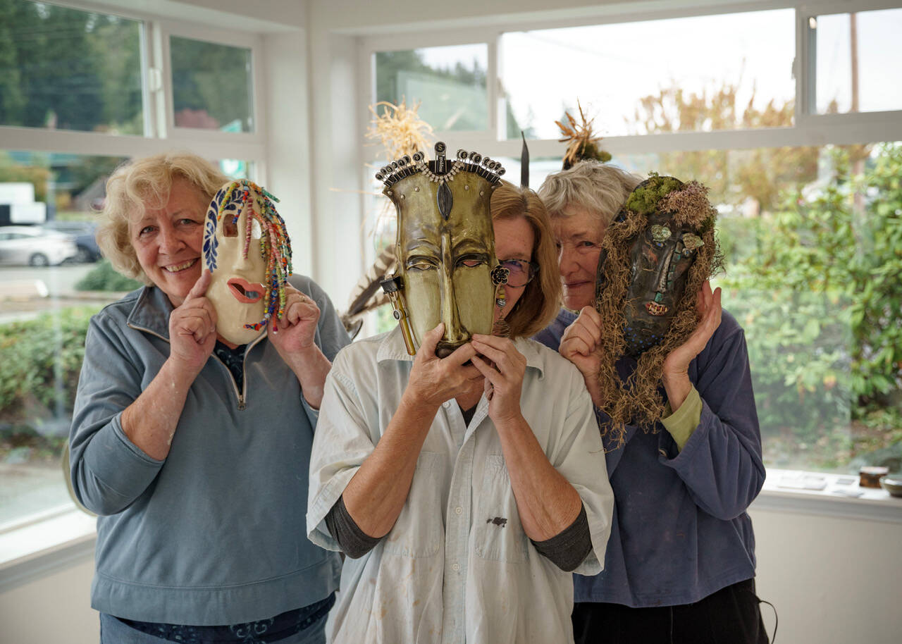 Photo by David Welton
Peggy Larmore, Karen Abel and Kristine McInvaille pose with some of the masks displayed at the Reveal/Conceal exhibit.
