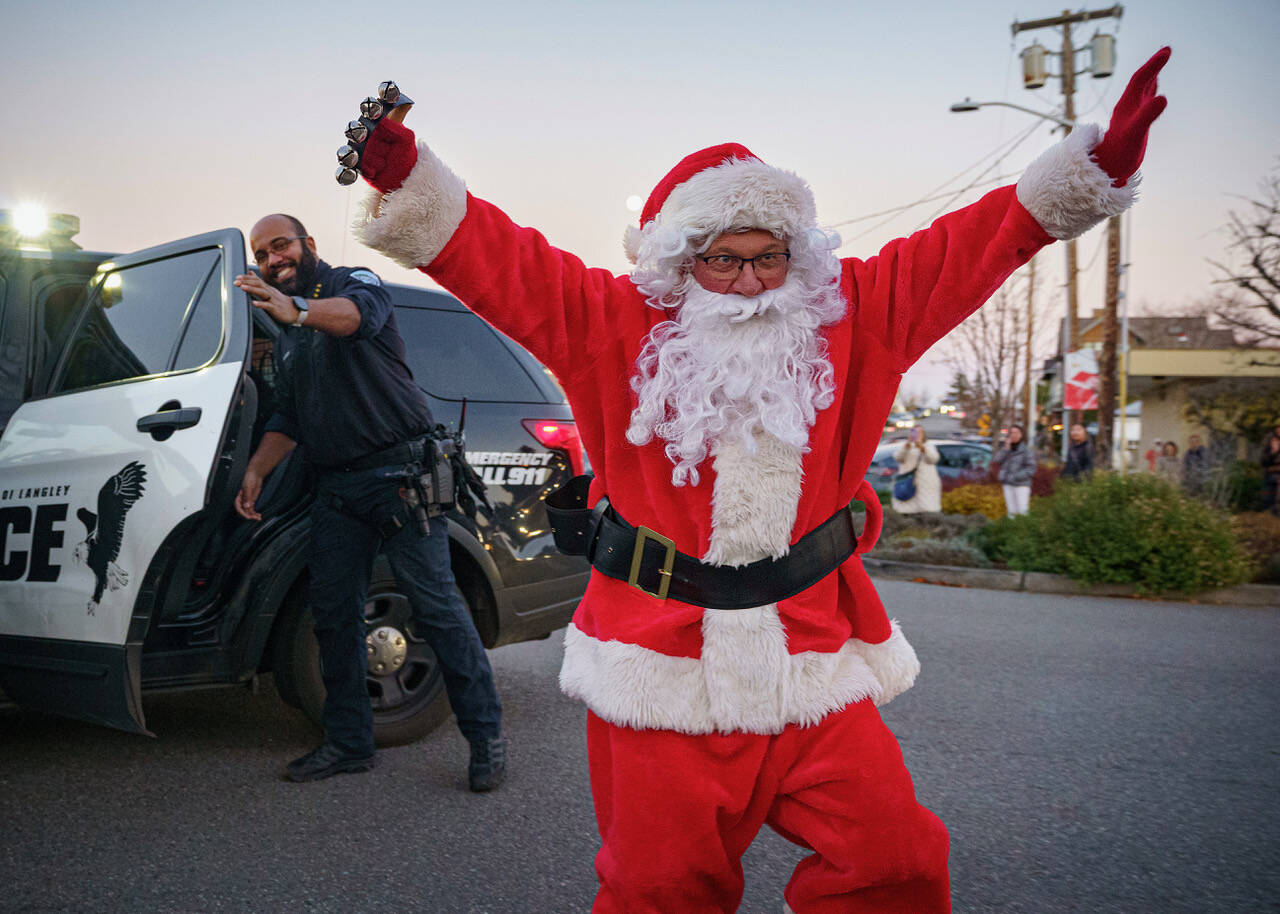 Santa Claus (Mark Stewart Cassidy) is escorted by Police Chief Tavier Wasser to the Lighting of Langley. More images from the event can be seen on page 8. (Photo by David Welton)