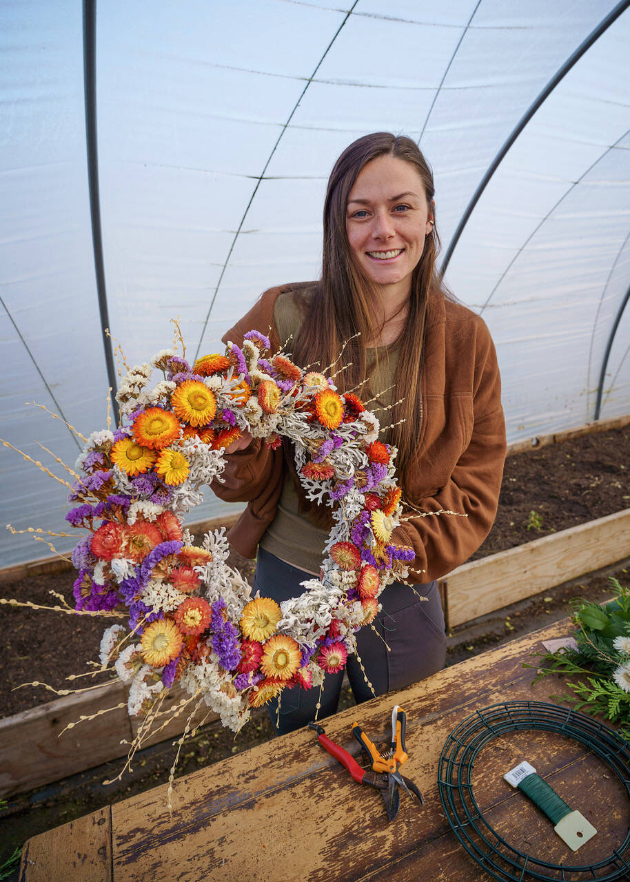 Emily Martin displays an everlasting wreath made from dried flowers — strawflower, statice and celosia. (Photo by David Welton)