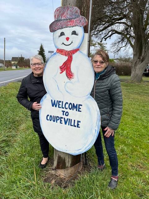 Sandee Allen, left, and Vicky Reyes greet a Coupeville snowman.