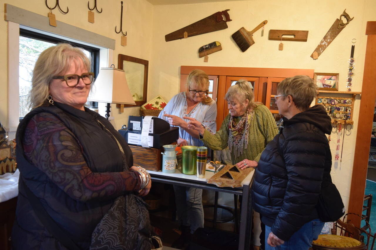 Whidbey Vintage Collective co-owners Heidi Norris, at left, and Leslie Jackson ring up purchases of Karen Heeney and Lori Sanford. The Freeland store opened in November. (Photo by Patricia Guthrie)