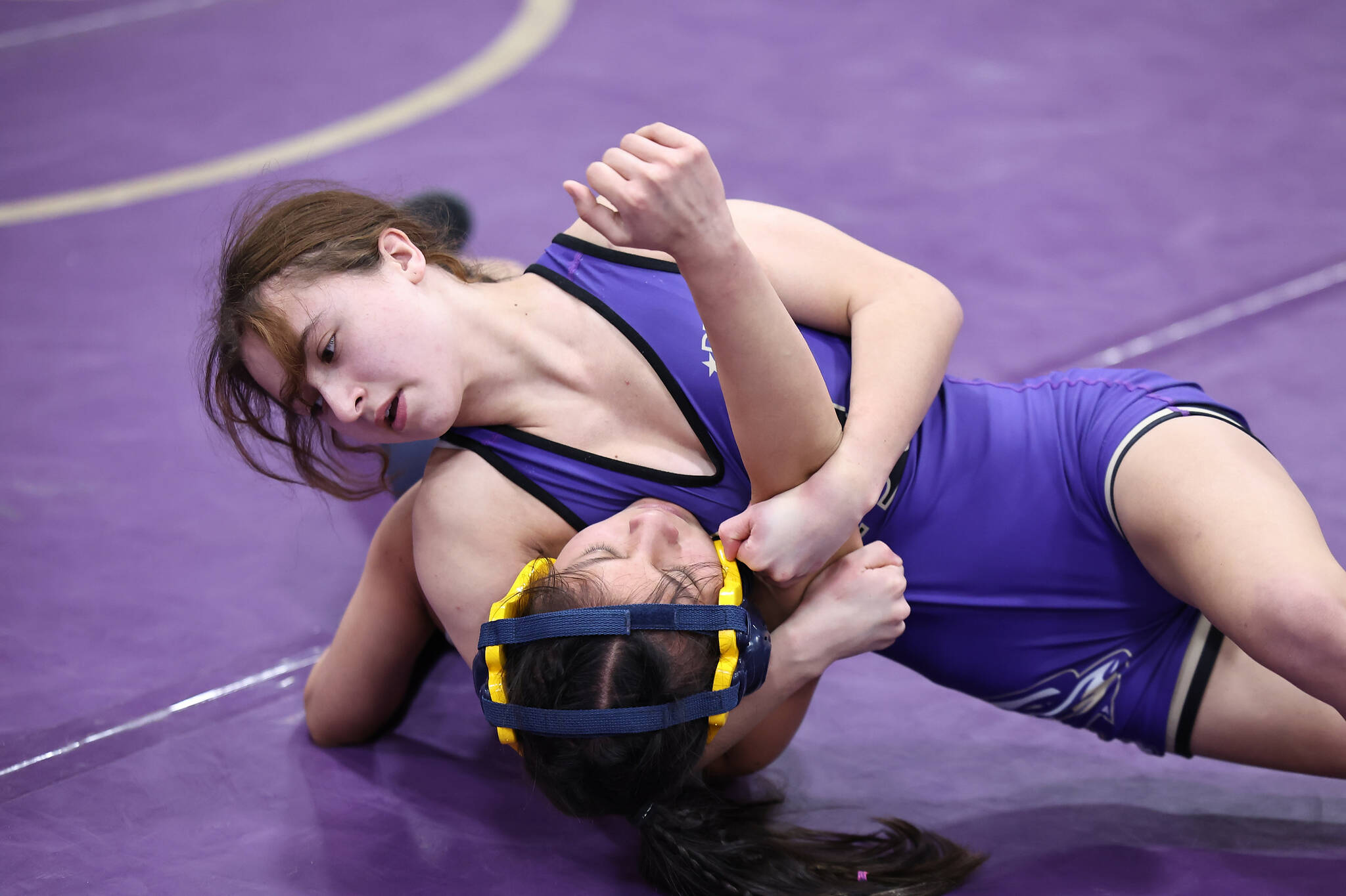Oak Harbor’s Julia Gonzales tries to pin an opponent during a match Saturday during the Rock Island Rumble tournament Saturday that saw 13 schools compete at Oak Harbor High School. Gonzales placed first in the 100-pound weight class. (Photo by John Fisken)
