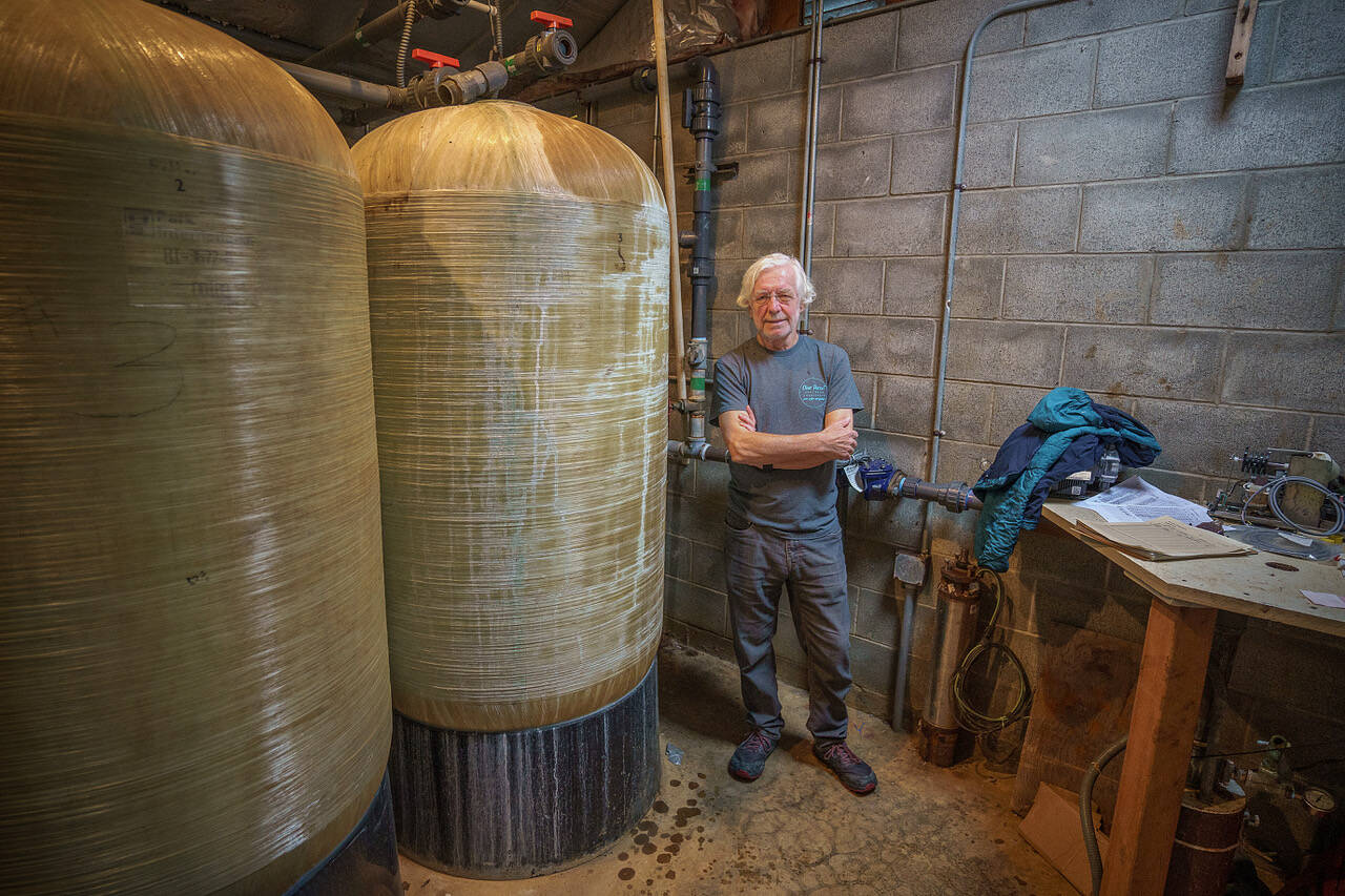John Lovie, an expert advisor on drinking water, stands near a greensand filtration system inside a well house on SOuth Whidbey. (Photo by David Welton)