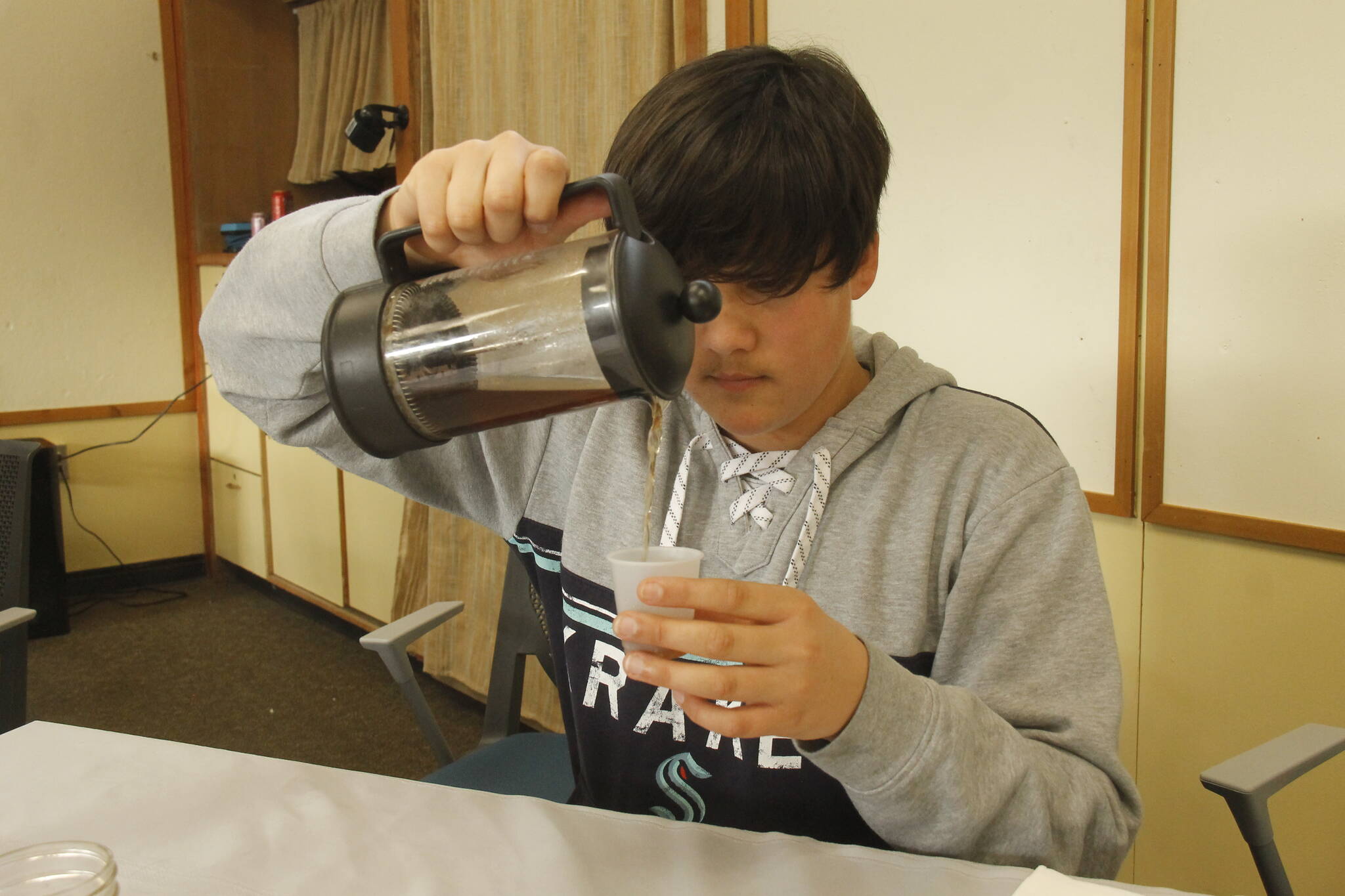 Ninth grader Liam Akhtar pours a tea of elderberry, chamomile and tulsi that he brewed. (Photo by Kira Erickson/South Whidbey Record)