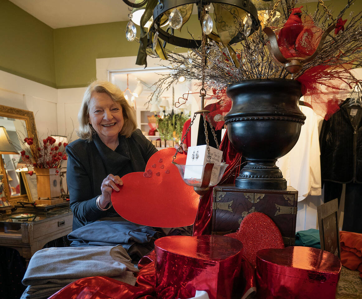 Cynthia Tilkin arranges a Valentine’s Day display of clothing at her store, In the Country. (Photo by David Welton)