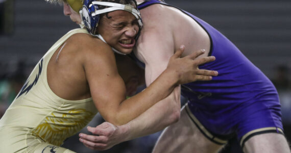 Arlington’s Tre Haines and Oak Harbor’s Percie Hatfield wrestle during the 3A boys 157-pound championship match during Mat Classic XXXV on Saturday, Feb. 17, 2024, at the Tacoma Dome in Tacoma. (Annie Barker / The Herald)