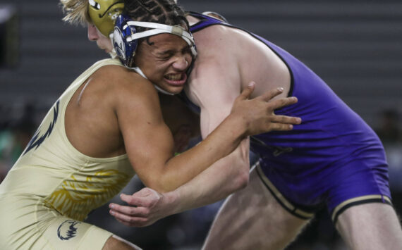Arlington’s Tre Haines and Oak Harbor’s Percie Hatfield wrestle during the 3A boys 157-pound championship match during Mat Classic XXXV on Saturday, Feb. 17, 2024, at the Tacoma Dome in Tacoma. (Annie Barker / The Herald)