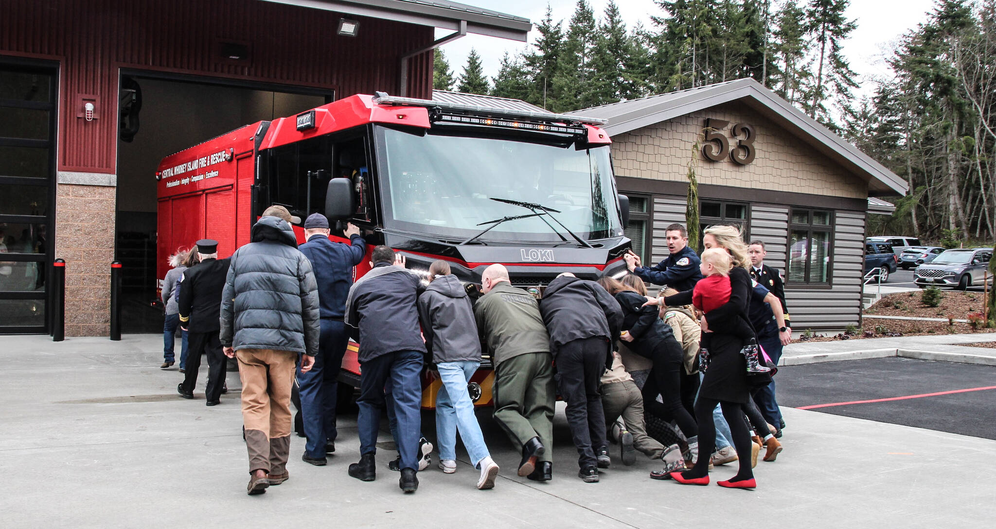 During the dedication ceremony, community members pushed a fire engine inside the new building. Fire Station 53 is dedicated to emergency responders and the citizens they protect. (Photo by Luisa Loi)