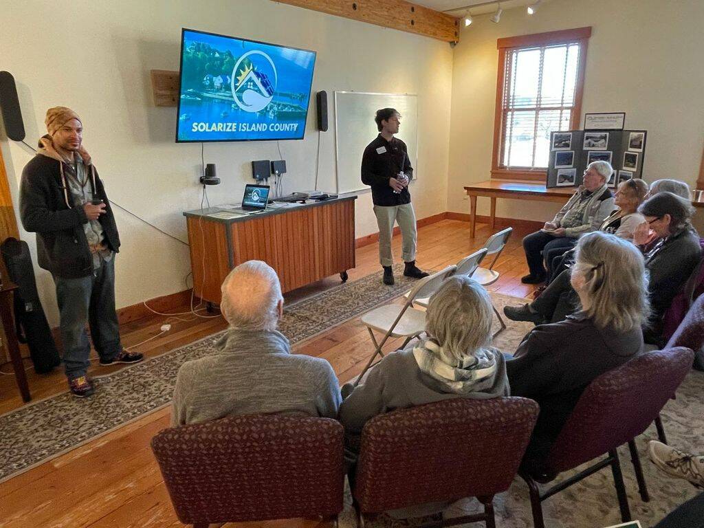 Ian Joseph Jackson, left, and Ben Silesky present Solarize Island County to South Whidbey residents at an informational session on Tuesday. (Photo provided)