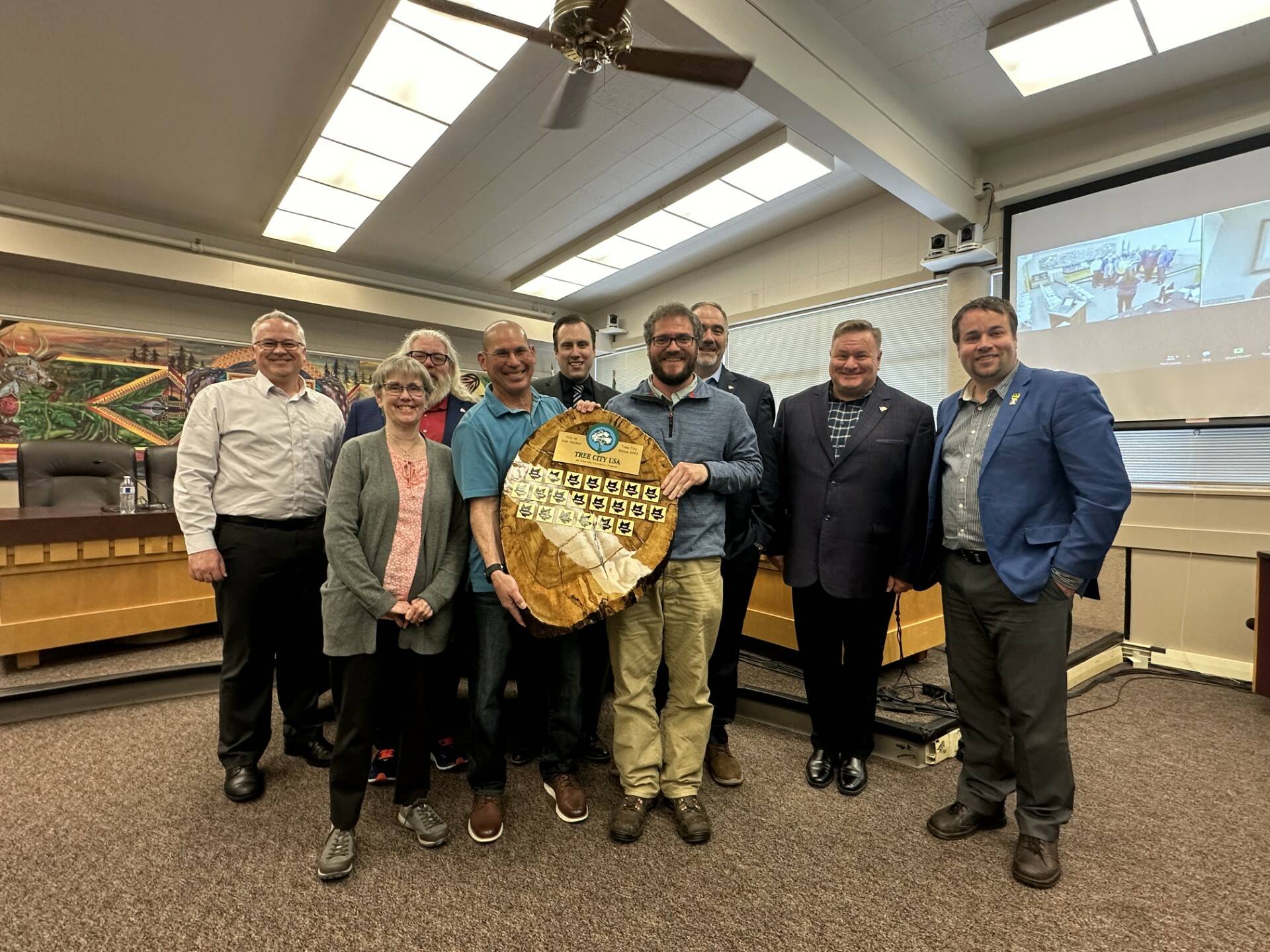 From left to right: Parks and Rec Director Brian Smith, Councilmember Barbara Armes, Councilmember Christopher Wiegenstein, Parks employee Bill Leuthe, Councilmember Bryan Stucky, Parks Supervisor Brandon Cable, Councilmember Eric Marshall, Mayor Ronnie Wright and Councilmember Shane Hoffmire present a plaque honoring the city’s 21st Tree City USA Designation at a city council meeting on Tuesday. (Photo provided)