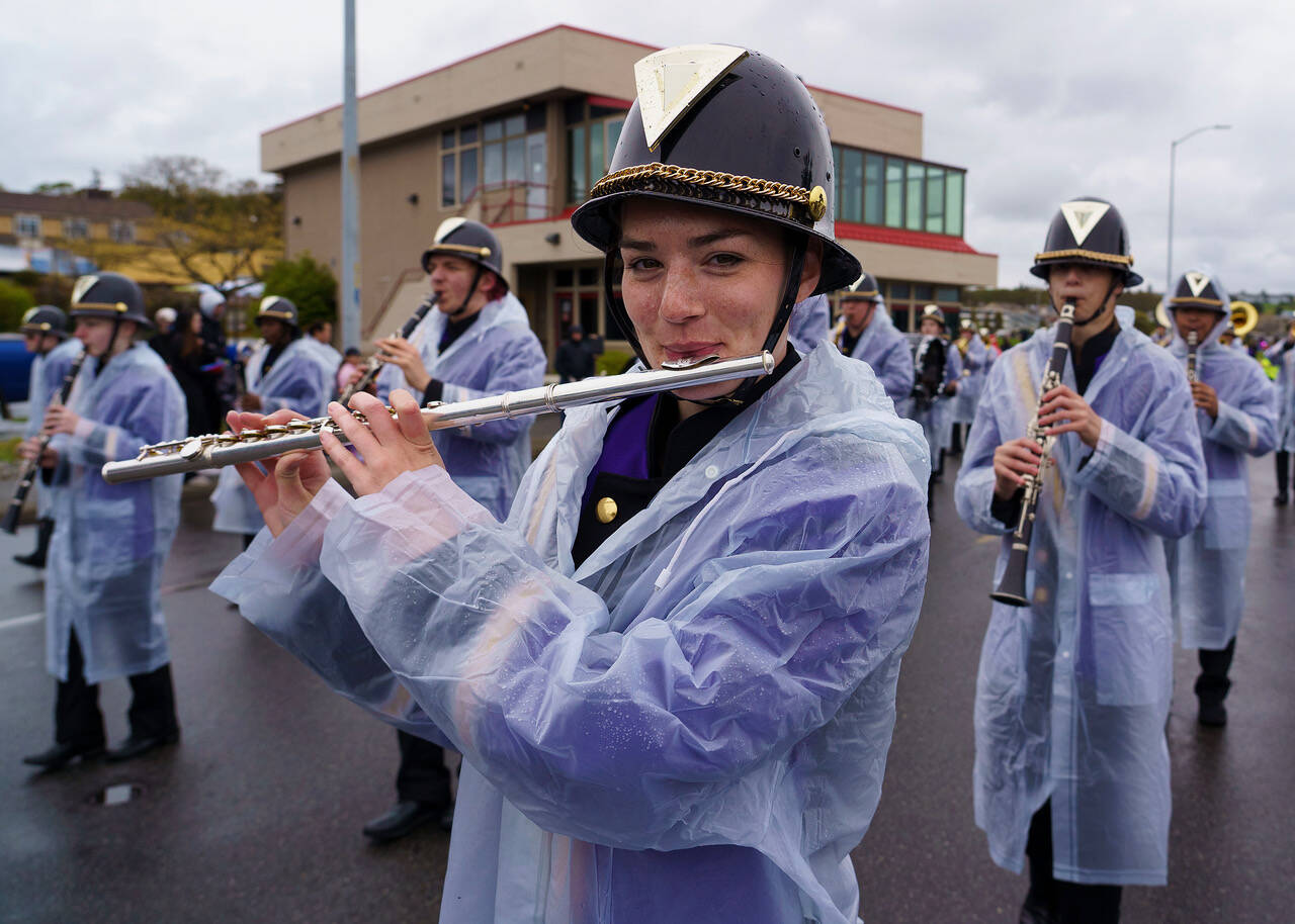 Oak Harbor High School senior Maggie Root tries to stay dry while marching and performing in the parade.