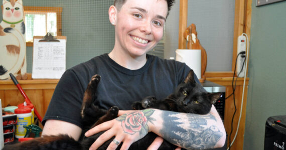 Animal care technician Morgan Kenaley with Shadow at the Freeland Cat Cottage. Photo by Mary Jo Adams.