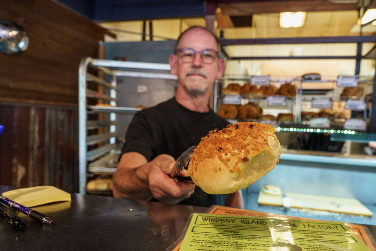 (Photo by David Welton) John Auburn serves up a cheese bagel at the Clinton shop.