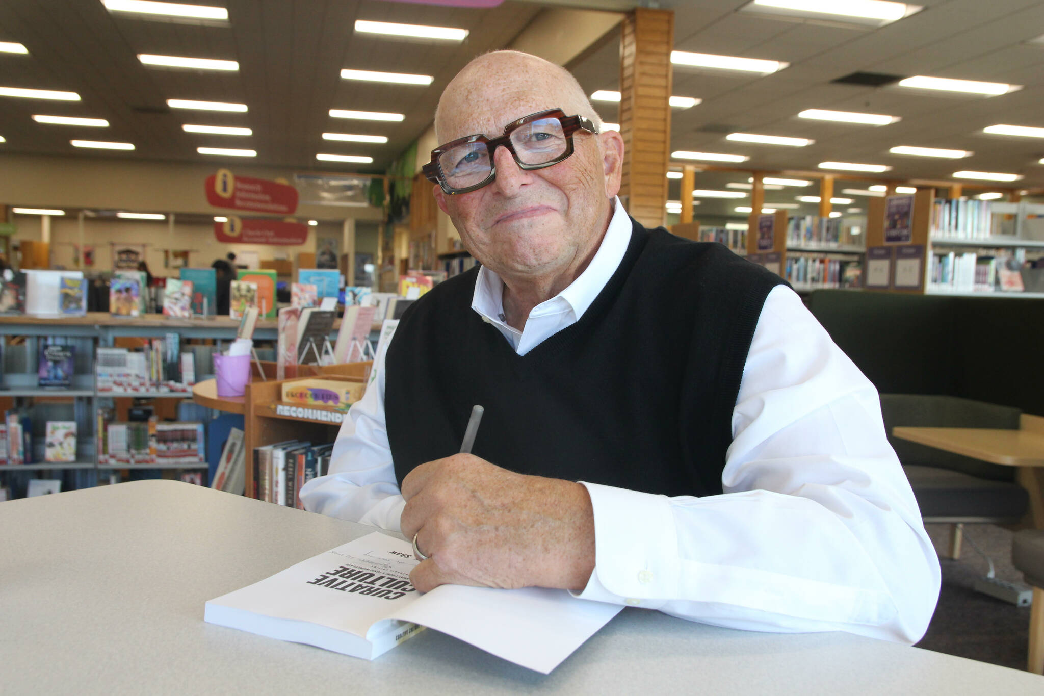 (Photo by Marina Blatt) Douglass Shaw signs a copy of his latest book, “Curative Culture.”