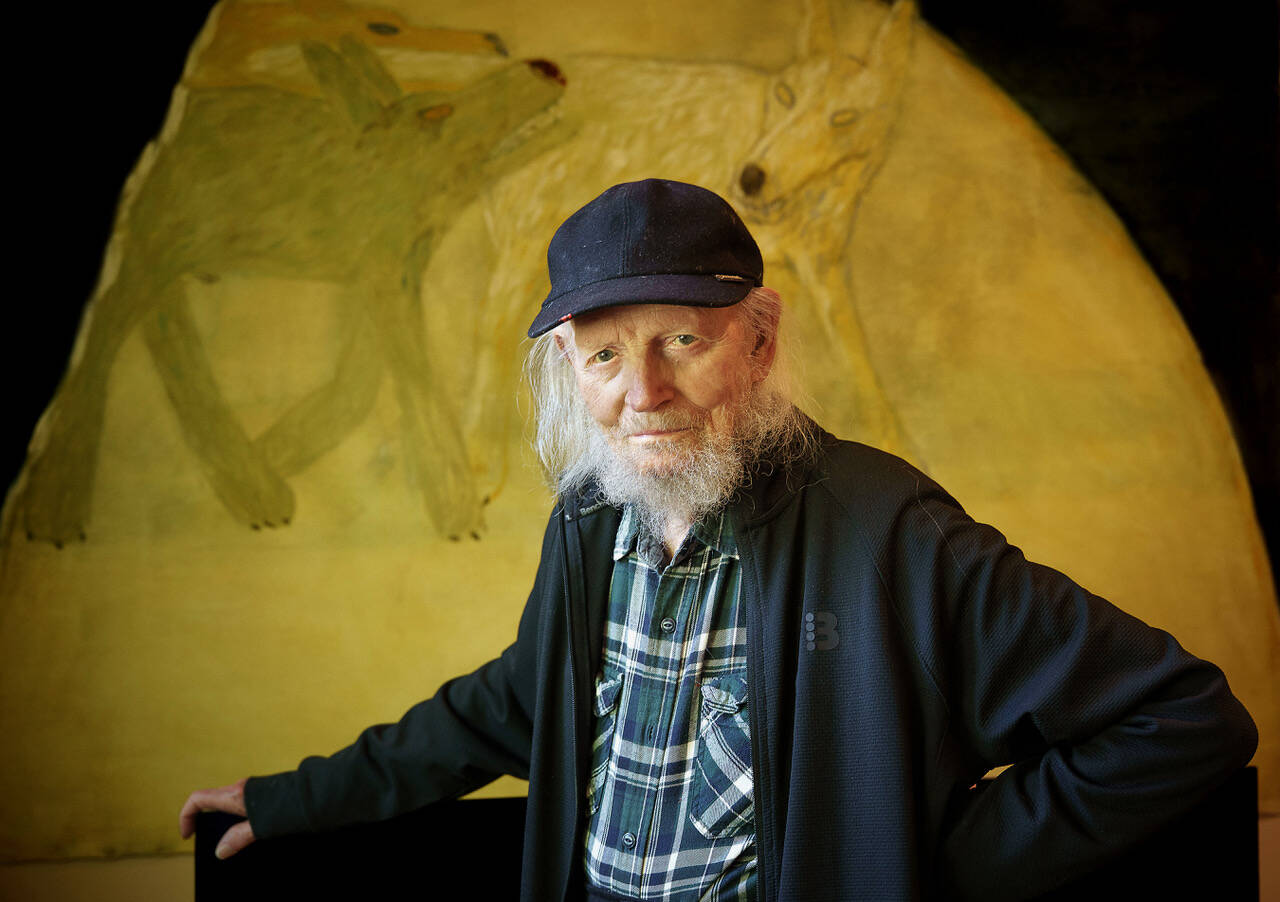 (Photo by David Welton) South Whidbey artist Gaylen Hansen, 104, stands before his painting of wolves. A prolific painter, Hansens works likely number in the thousands.