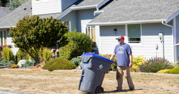 Photo provided by Island Disposal. James Andersen takes an Island Disposal recycling container out to the curb.