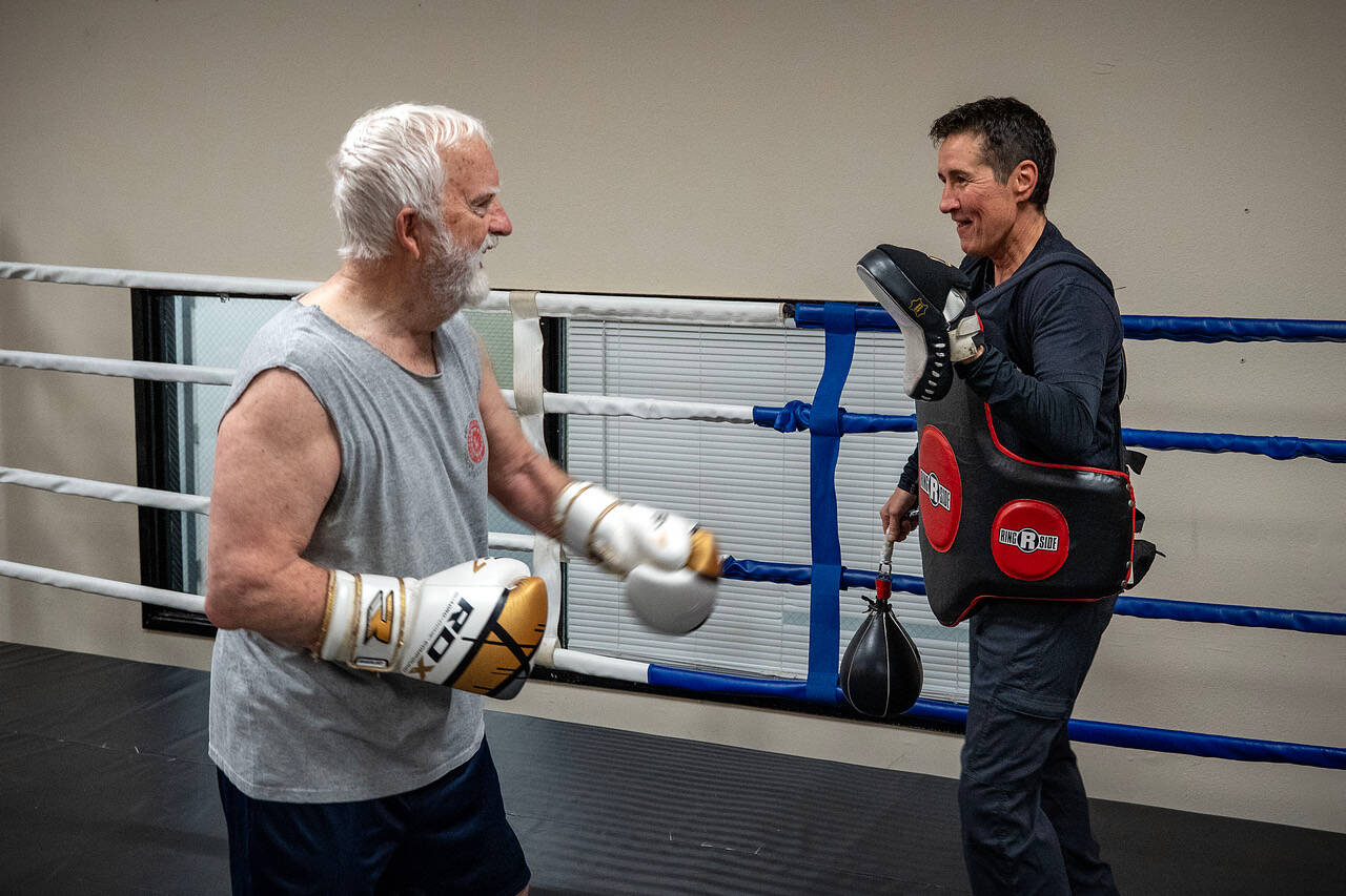 Gary Goltz hits mitts in the ring with Dakota Stones encouragement during a class at Solid Stone Boxing Gym for people with Parkinsons disease. (Photo by David Welton)