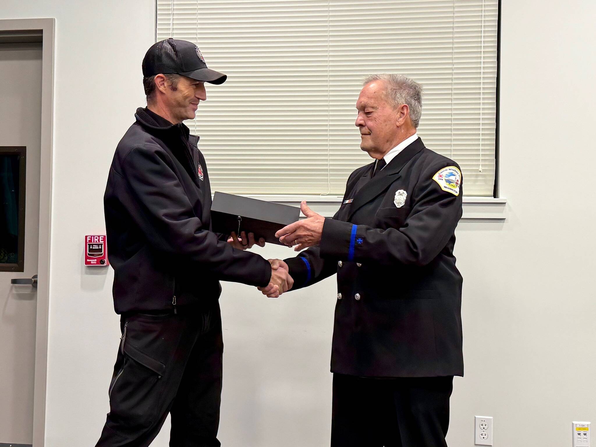 Fire Chief Jerry Helm congratulates Bob Moore on 15 years of volunteer service at a ceremony earlier this month. (Photo by Central Whidbey Island Fire and Rescue)
