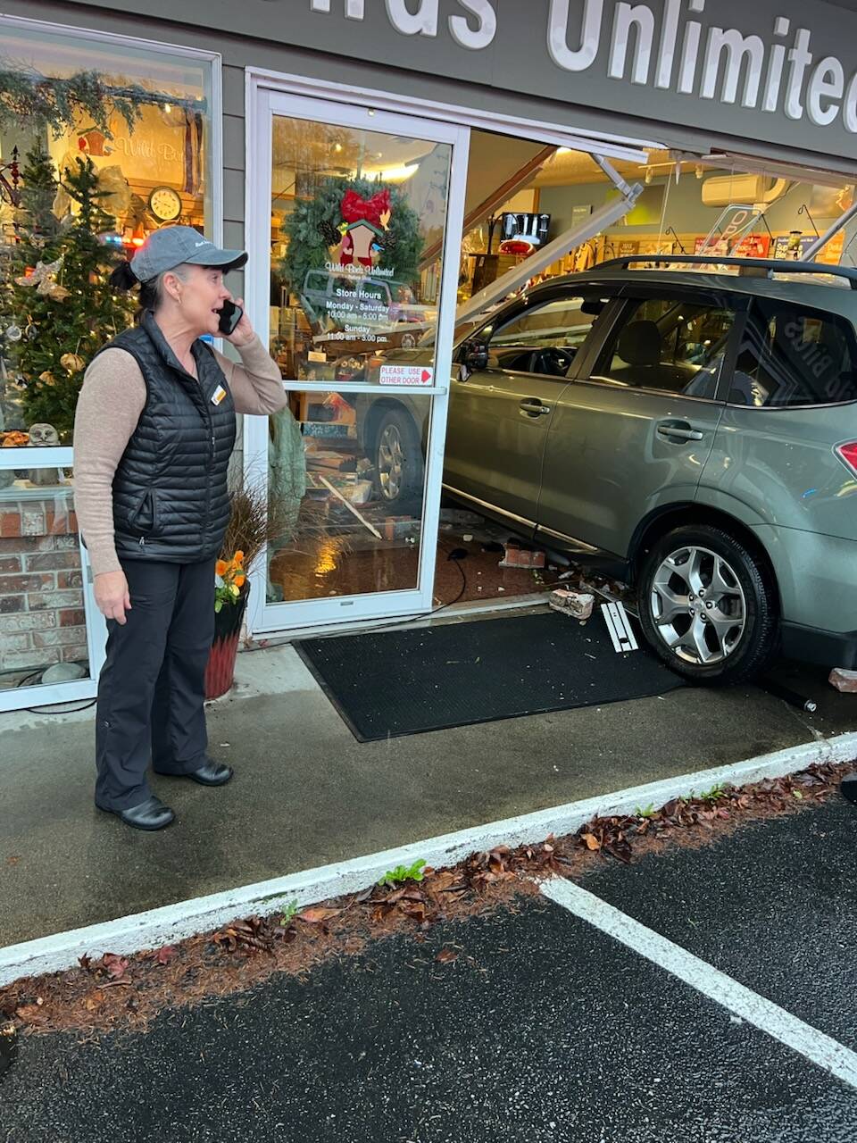 Photo provided by John Norris
A car crashed into Wild Birds Unlimited in Freeland last week. Owner Noel Nic’Fergusson looks on while on the phone.