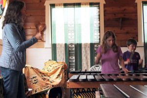 Rubatano Director Dana Moffett (left) uses Zimbabwean shakers to maintain the beat during her “Nyeredzi” kids class as Naomi Atwood (center) and Ian O’Brien (right) play the marimba.