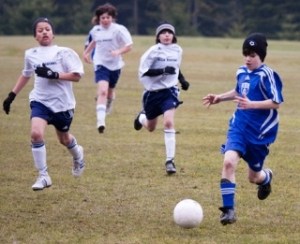 South Whidbey Revolution soccer player Jeffrey Meier outpaces his Blue Arrow  opponents Saturday. The U-12 victory means the team continues its championship quest in Tukwila