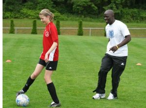 Former South Whidbey High School soccer star Joseph Supang encourages Theresa Edwards to watch her feet and control the ball during Supang’s soccer camp.