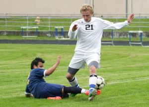 Burlington-Edison junior Bryan Granados slides after the ball as South Whidbey senior defender Sam Lee attempts to clear the ball Tuesday at South Whidbey High School.