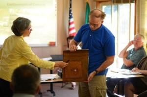 State Department of Ecology officials Louise Bardy and Eugene Freeman show a section of a holed underground fuel tank during a Freeland Water and Sewer District meeting Monday. Thousands of gallons of gasoline leaked through a similar hole in a former Freeland gas station.