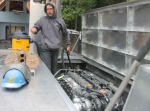 Tim Leonard cleans one of the engine compartments of the 32-foot catamaran for South Whidbey Fire/EMS.