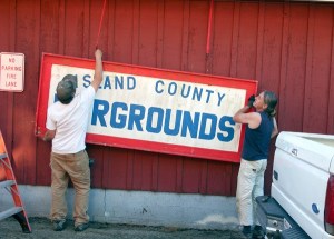 Timothy Hull and another volunteer put up the old fair sign which