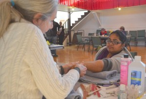 Linda Jacobson gives a hand massage to Rena Heino during an event to count the homeless on a community and national level on Thursday