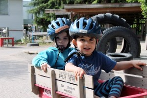 Penelope Isenhower and River Sanchez ride a wagon at the Whidbey Island Children’s Center during a daytime program. The children’s center offers year-round programs and summer programs for school-aged children.