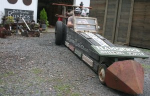 Bob Bowling shows off the racer he will enter in Saturday’s Soup Box Derby in Langley. The short course is an open soap box downhill race and features many imaginative race cars. Bowling’s is in line with his career as a rustics artist who uses old materials to fashion new sheds and garden art.