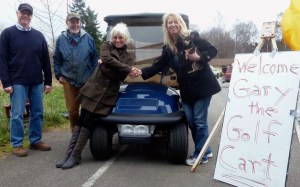 Mayor Fred McCarthy and City Councilman Jim Sundberg look on as Langley Main Street Association President Janet Ploof and Suzan Torguson of NW Green Cars shake on the shuttle deal.