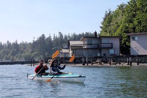 Whibey Island Kayaking tour guide Kevin Murphy (left) shows tour guest Erin Masterson around Langley Marina. Tours also depart from Possession Point and Penn Cove.