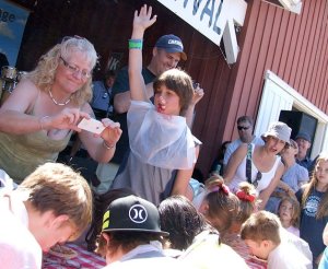 The winner of a pie-eating contest raises his hand in victory. The annual Loganberry Festival has been cancelled this year due to a scheduling conflict.