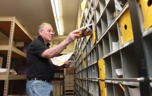 James Wills files mail into post office boxes at the Clinton post office Monday. After a 34-year career at the Clinton post office