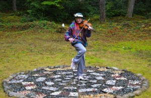 Talia Toni Marcus plays the violin on a mosaic created by Sarah Letitia Wallace. Wallace was diagnosed with Alzheimer’s in 2001