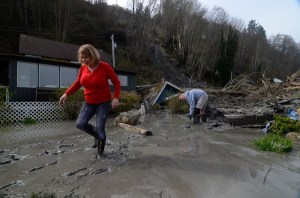 Judi Sladky slogs through mud at her Brighton Beach home Monday following another major landslide. County officials yellow tagged the home later that day.