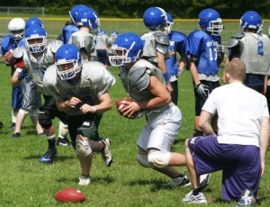 Falcon quarterback Avery Buechner hands off the ball to fullback Mason Shoudy as tailback Sam Lee