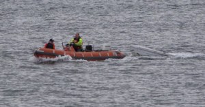 Crew members of the Clinton-Mukilteo M/V Kittitas tow a wayward dinghy out of the ferry lanes last week.