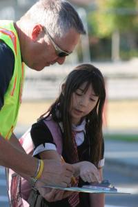 South Whidbey Elementary School para-educator Denny Keough helps guide Marla Kelly to her class on the first day of school. South Whidbey School District officials said the initial count of student enrollment shows fewer students will be attending South End schools this year.