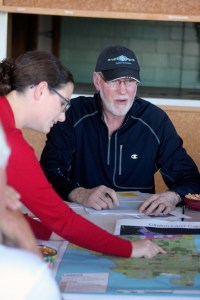 Jack Lynch speaks during a Clinton Community Council meeting while Amanda Almgren with Island County Planning points to zoning areas on a map.